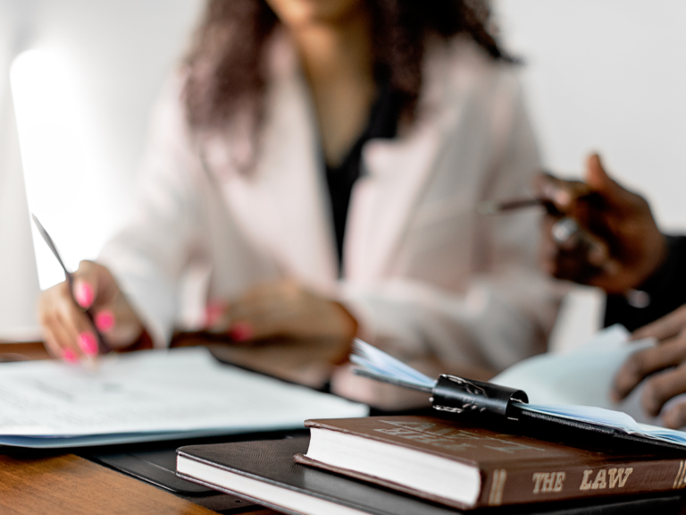 Deux personnes devant un bureau avec des livres sur la loi